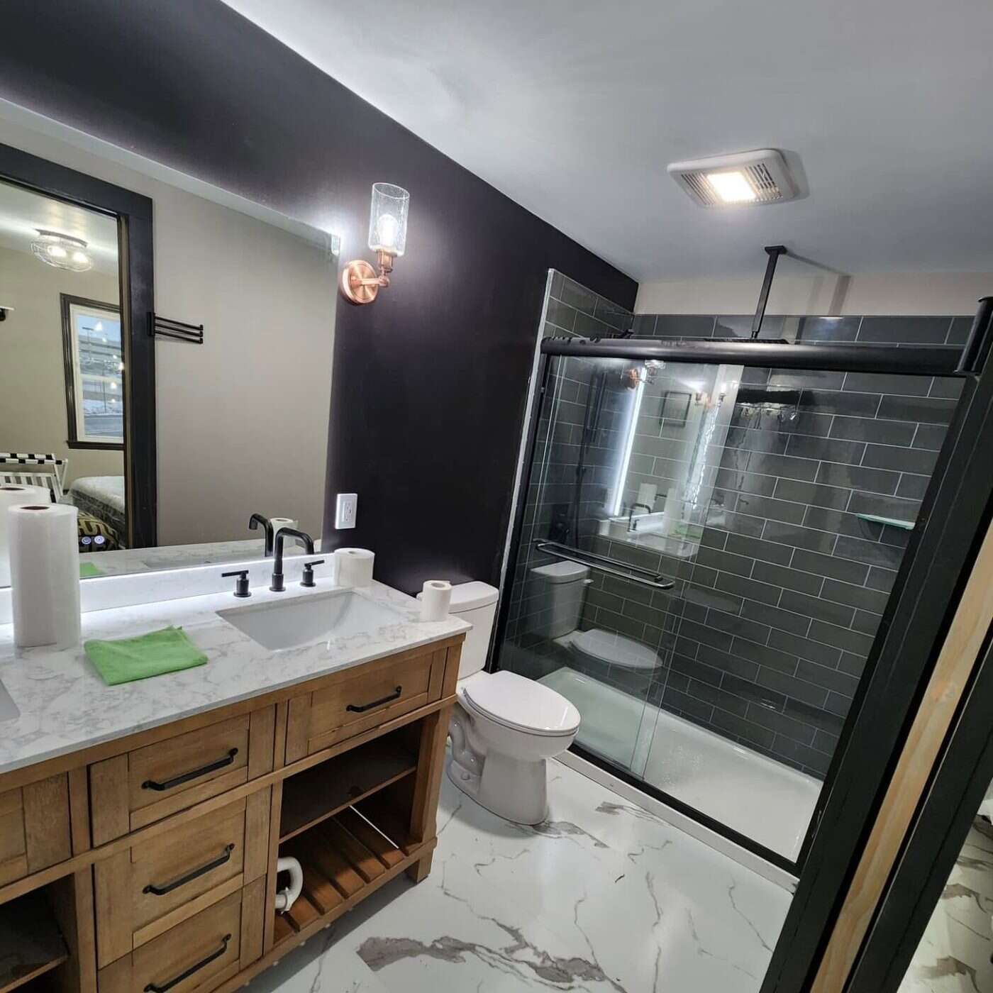 Custom tiled bathroom with walk-in shower and marble vanity, completed by Diamond D Tile & Construction