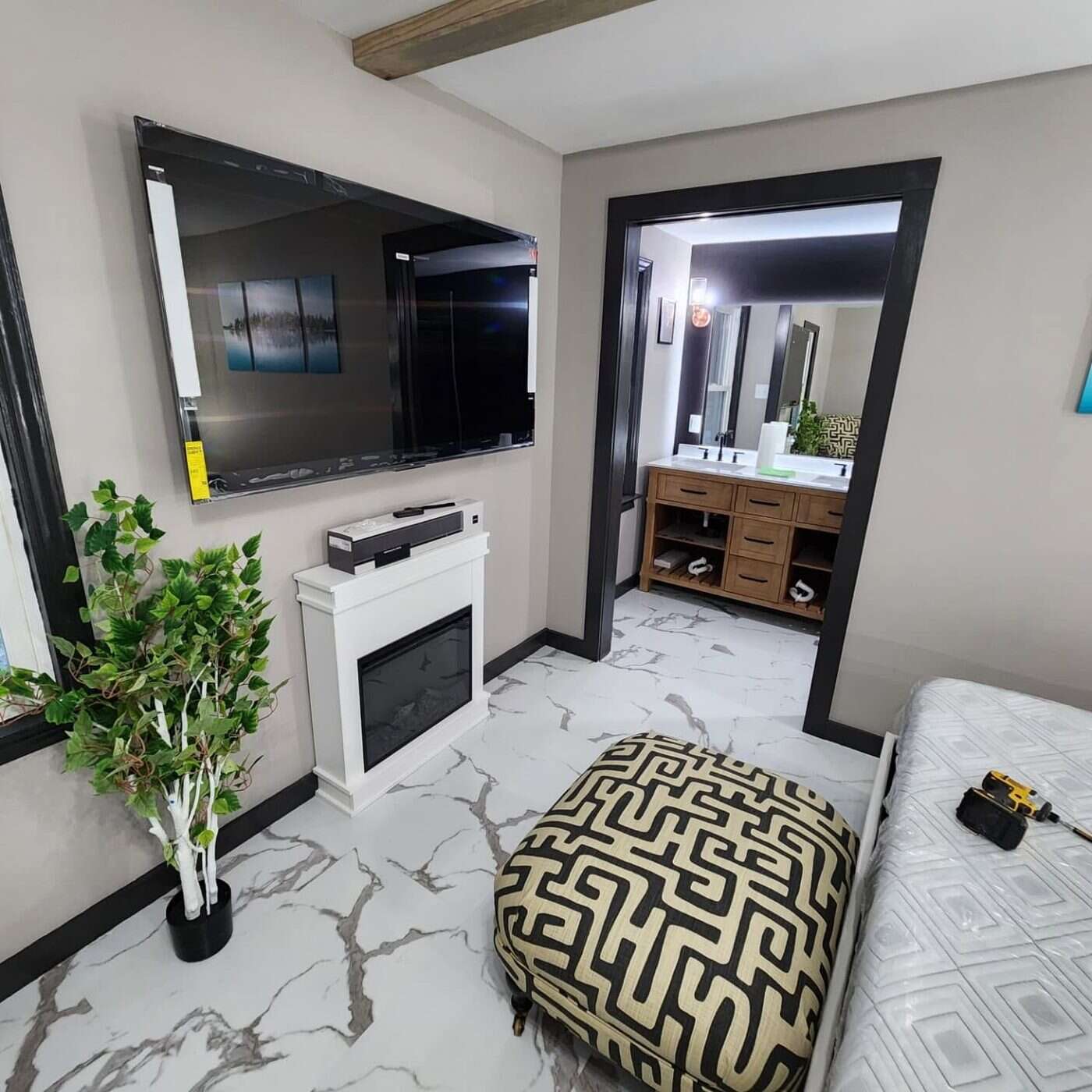 Primary bedroom with marble-look tile floor and black slat accent wall