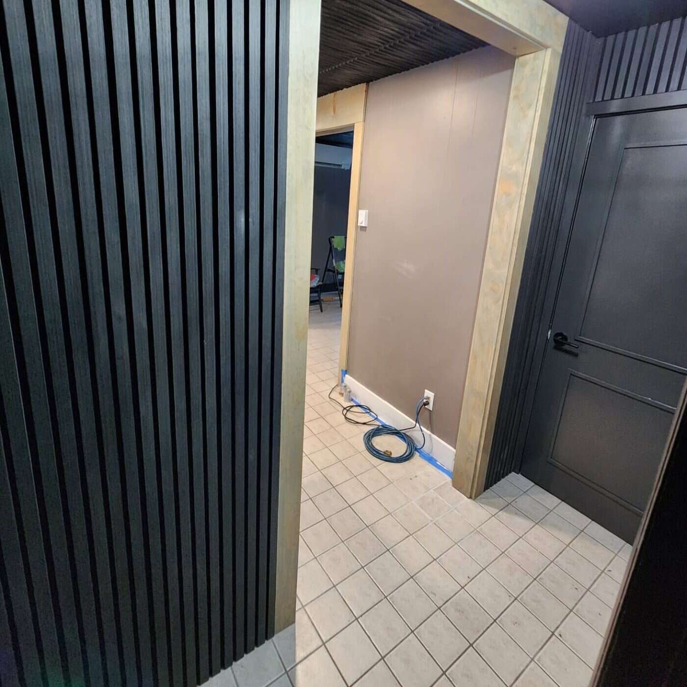 Hallway with dark wood-slat paneled walls