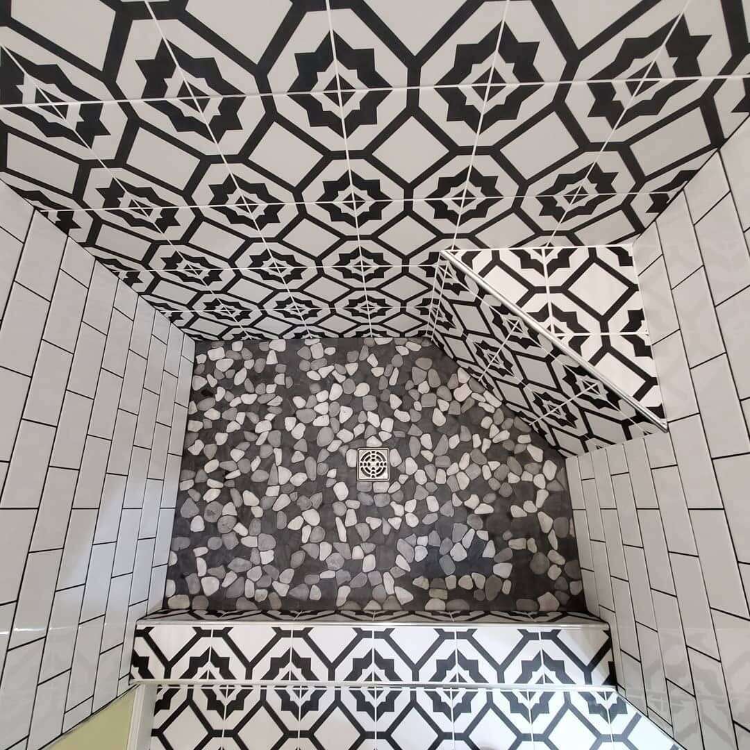 Overhead view of patterned shower with pebble floor and bench