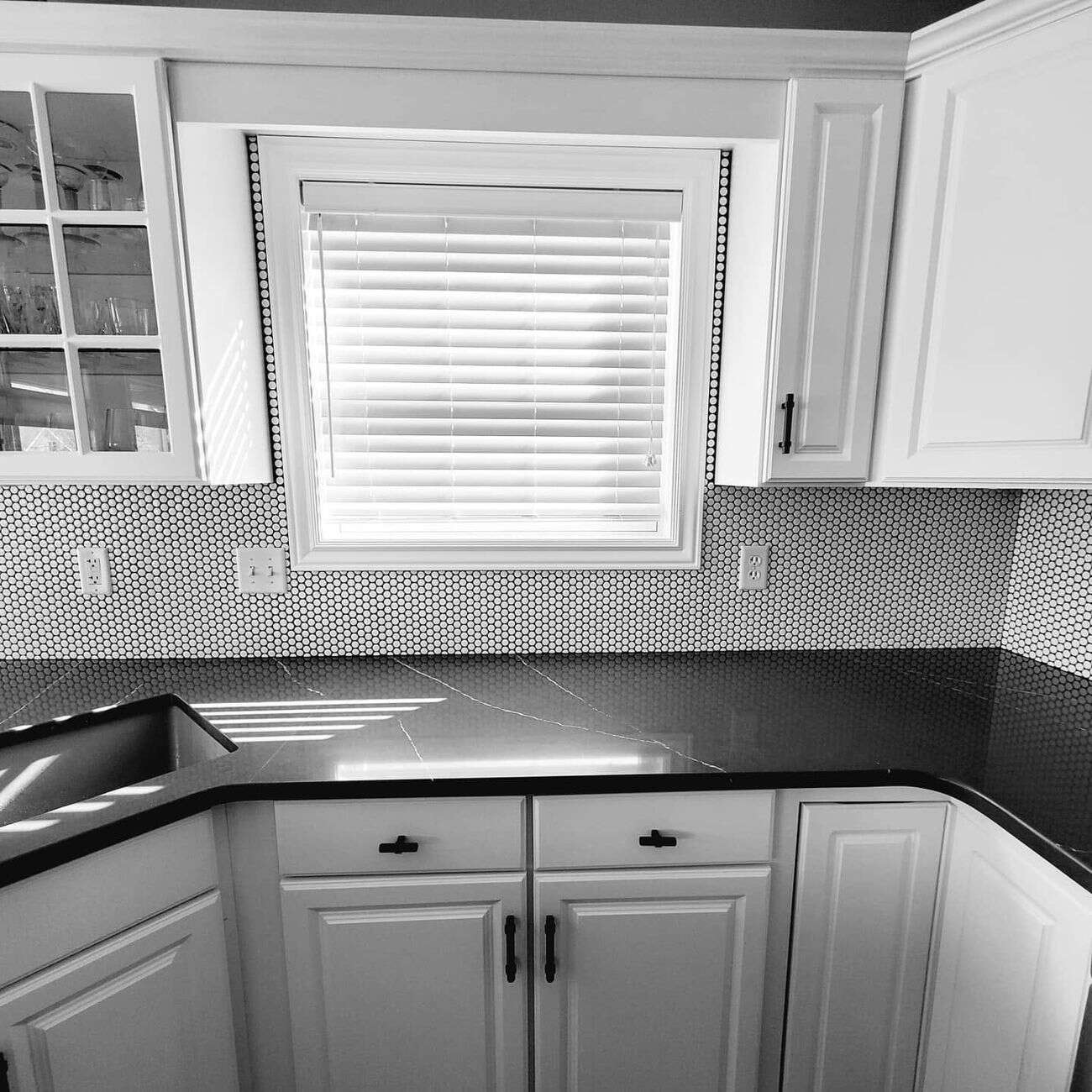Penny-round tile backsplash behind range with black hardware