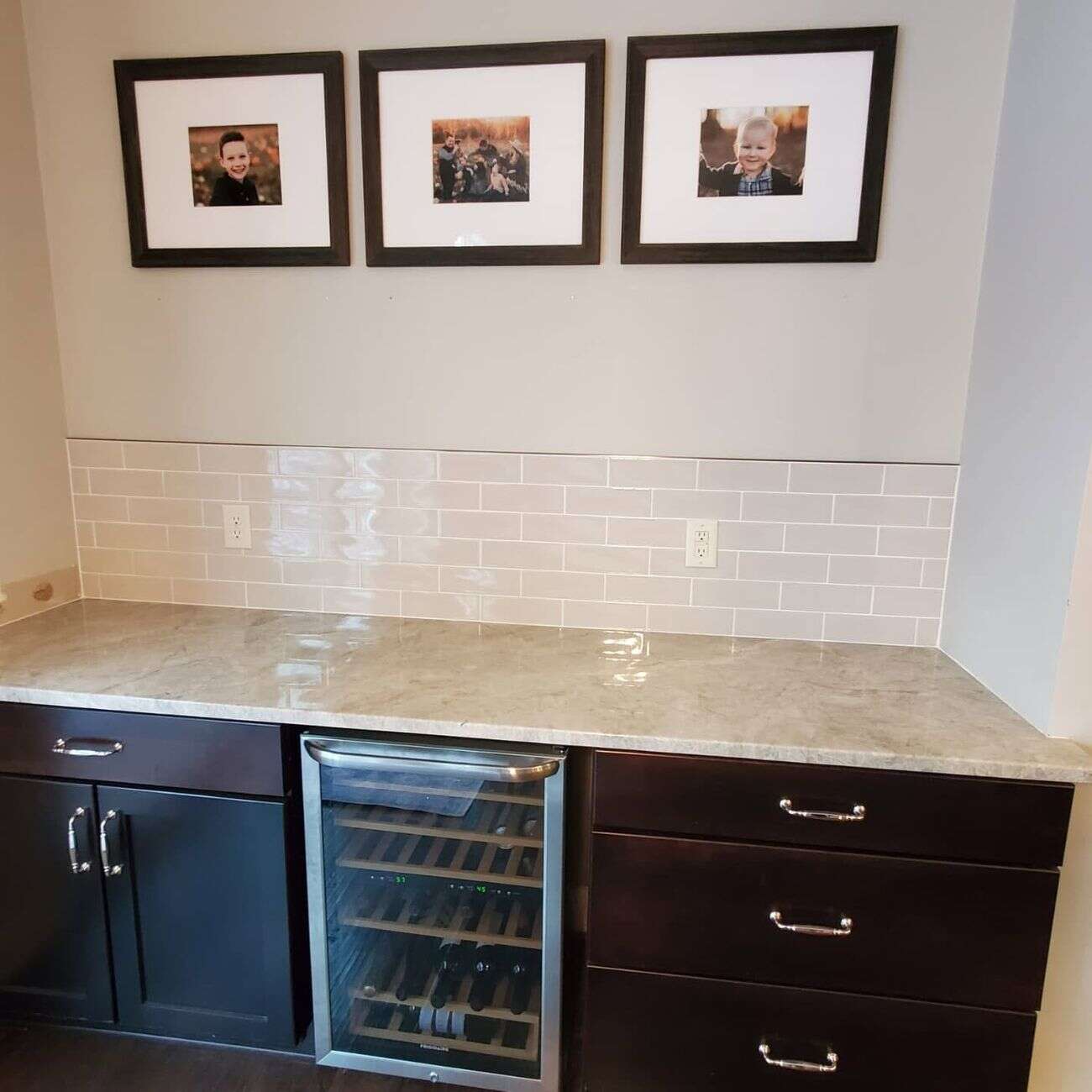 Wet bar with glossy subway tile backsplash and marble counter