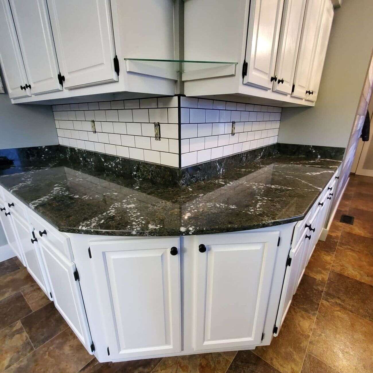 White subway tile backsplash with dark grout above granite